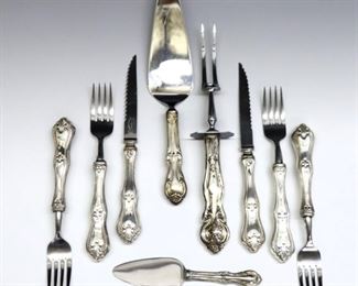 Twenty-one pieces of Sterling Silver hollow handle flatware.  Includes a matching set of 6 x 8 3/4" steak knives and 12 x 8" dinner forks, with 3 x 6 to 10 1/2" serving utensils of similar patterns.  Each impressed "Sterling", carving fork with Frank M. Whiting maker's mark.  Approximately 10.5 troy ozs total weight.  Some wear and minor damage, several forks separating with repairs where stainless steel connects to handle.  ESTIMATE $200-300
