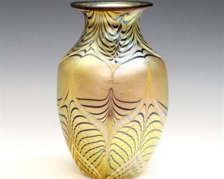 A late 20th century Orient & Flume Co. Art Glass vase.  Round form with flared rim, Gold and Navy irredescent pulled feather design.  Original sticker at underside.  Minor wear.  7" high.  ESTIMATE $100-200  
