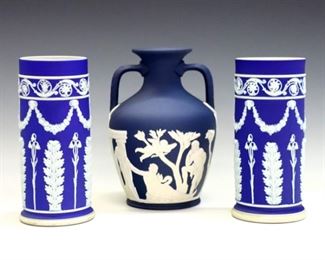 Three 20th century Wedgwood vases.  Jasper dipped bodies with vintage garlands and classical figures in White relief.  Includes two early Royal Blue spill vases and a later Portland Blue two-handled vase.  Impressed marks.  Minor surface wear.  Up to 6" high.  ESTIMATE $200-300
