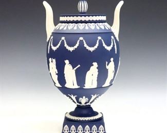 A late 20th century Wedgwood covered urn.  Portland Blue Jasper dipped body with vintage garlands and classical figures in White relief.  Impressed marks.  Minor wear.  12 1/2" high.  ESTIMATE $200-400
