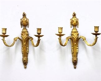 A pair of early 20th century French Bronze Louis XVI style sconces with Gilded finish.  Draped urn finials above two scrolled arms with chased Acanthus leaf detail and goat head masks on tapered bodies.  Minor wear to Gilding, slight pitting.  Each 10 x 5 x 13" high overall.  ESTIMATE $400-600