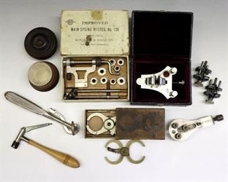 A group of watchmaker's tools and gauges by various makers.  Includes a HvH poising tool with Ruby jaws, K&D "No. 128" main spring winder, two truing calipers, two C&E Marshall movement holders, a jaxa style case opener, with other clamps and accessories.  Various stages of wear.  Up to 6 1/2" long.  ESTIMATE $200-300