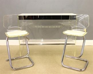 A 1970's bar and stools designed by Luigi Bardini for Hill Manufacturing.  Includes a bar with White Formica top and mirrored skirt with incorporated drawer, on a Lucite base with barware shelf and bottle racks on either end, lower shelf and interior light (53 1/2 x 17 1/2 x 40 1/4" high) en suite with two bar stools with molded Lucite shells and shaped chromed bases.  Some minor wear.  ESTIMATE $800-1,200