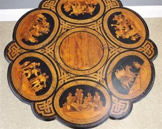 An early 19th century Venetian Marquetry center table.  Lobed circular top with intricate marquetry panels depicting rural Italian life on a conforming apron with geometric parquetry inlay, pedestal base with urn shaped stem and flattened tripod base.  Restored finish with losses and older repairs, shrinkage cracks in top, veneer damage.  Approximately 36" diameter x 31" high overall.   ESTIMATE $1,000-1,500