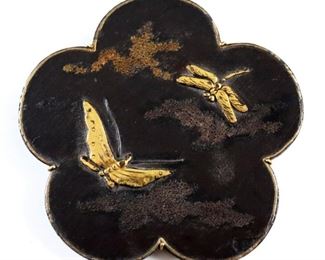 A late 19th to early 20th century Japanese Meiji Period mixed metal plaque.  Floral form decorated with a butterfly and dragonfly in relief, fitted with a custom gold hanger at back.  Minor wear.  2" high.  ESTIMATE $400-600  NOTE: Includes a sale invoice from Haig's of Rochester, Michigan.