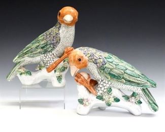 A pair of Chinese Famille Rose porcelain parrots.  Parrot forms perched on stumps with hand-painted polychrome decoration and applied floral details.  Minor wear to decoration, one petal broken, a few others with tiny chips.  Up to 9" high.  ESTIMATE $200-400