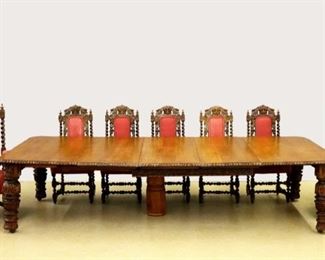 A late 19th century British wind-out dining table with three leaves.  Solid Oak construction with a carved gadrooned top and carved foliate skirt supported by four substantial turned legs with carved detail.  Older refinishing with minor wear, includes two later turned columns for support when fully extended.  59 x 62 (with three 22" leaves opens to 128") x 29 1/2" high overall.  ESTIMATE $1,000-2,000  NOTE: Chairs sell separately