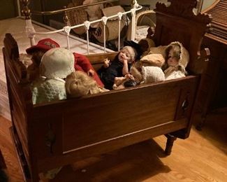 . . . . a vintage cradle filled with dolls