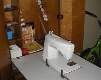Sewing Machine and accessories in fold down Cabinet.