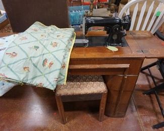 sewing machine in cabinet with bench, quilts