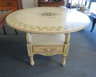 Round drop leaf table with one drawer.
