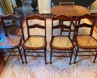 $180- LOT 4 - 4 cane bottom chairs. 33 inches high at back, 18 inches high at seat. 2 of the chairs have wider caning with damage. 