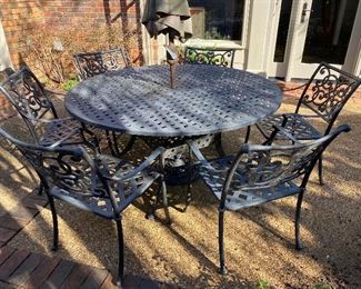 $495 - LOT 23 - Round cast aluminum patio table with 6 chairs. 5 feet in diameter. 