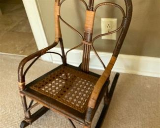$35 - LOT 37 - Child's cane rocker. 22.5 inches tall, 13 inches wide, 20 inch long rockers.