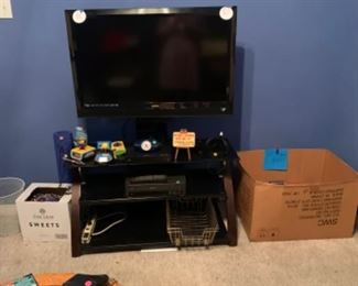 Vizio 37 inch tv on tv stand, Nampo plug and play controllers, VHS player, VH s tapes, Mardi Gras beads
