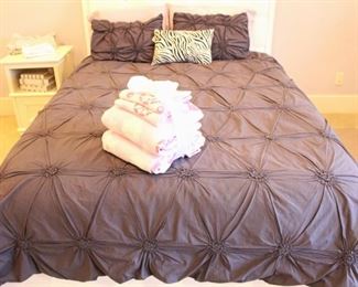 This queen size mattress and box springs  and bedding are for purchase.  The headboard and nightstand pictured stay with the home. Also for sale is the Pottery Barn Charcoal Ruched Duvet and shams.
