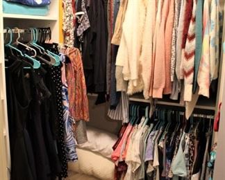 Closet is full of bedding and teenage girls' clothing.