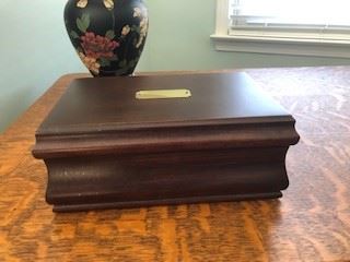 Cigar/jewelry box, solid walnut. Hooks inside to hand watches or chains. No inscription on brass inlay. Red felt inside, removable tray box. 