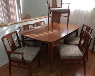 mid century dining table and cane back chairs. has leaf. laminate top
