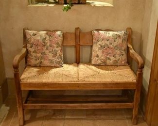 Wood loveseat bench with woven seats. 