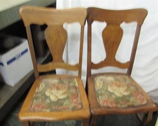 2 wooden chairs with floral cushioned bottoms.