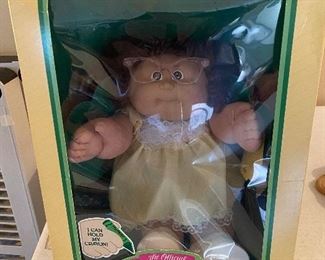 Vintage Caleco 1985 Cabbage Patch Kids doll with glasses, holds a crayon, and adoption papers. In original box, good condition.