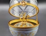 Faberge Limoges Serie Limitee Crystal Egg. Whimsically designed with a  race horse and jockey inside! Number piece measures 6” high and 3”wide.

Rare and beautiful, this hand painted Limoges green and gold porcelain Faberge egg has a hand-cut crystal top that opens to a thoroughbred race-horse and jockey. The egg sits in an attached 3 leg decorative stand. The inside, based on like pieces, is 24k gold plate over sterling. Precious Faberge eggs are handmade in Limoges (France) - in the centuries-old traditions, each of which is 24K gold plated. Faberge eggs are perfect for celebrating special moments or events and each egg is signed and numbered.
