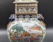 Beautiful Painted Chinese Covered Jar with Figural Foo Dog Handles and Top. Both sides have intricate scenic details! Measures 15” high and 9” wide.