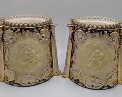 Benrose Italian Painted Planters featuring a lovely embossed design depicting a tender moment between a couple. Accented with gold detailing.

The inside of both is removable and looks to be used for plants/flower pots. Each measures about 9” high and 7” in diameter.
