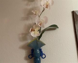 Artificial orchid in blue mounted vase