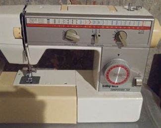 Lower Level-Storage Room:  A vintage "Baby-Lock Companion #722" [Model H71871883] sewing machine is to the left of a box of fabric remnants and sewing notions.