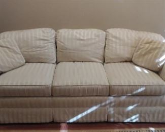 Lower Level:  An ivory tone-on-tone stripe sofa has six detached cushions and two toss pillows.  It measures 88" long.