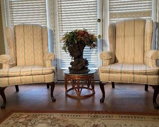 Lower Level:  Two HENREDON wingback chairs are individually priced and flank a glass top rattan table and floral arrangement (see next photo).