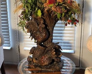 Lower Level:  A tall hen and chick resin planter displays fall florals on the rattan/glass table.