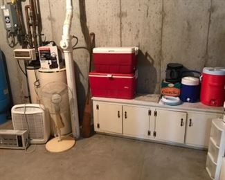 Lower Level-Tool Room: Shown are IGLOO water coolers and ice chests; a  heavy gauge cook set; a custom made cabinet; HONEYWELL pedestal fan; WHISPURE 510 air filter; HOMEBASIX space heater; EVERBUILT 3/4 horsepower cast iron sump pump (with manual); and a vintage  wooden boat paddle to the left of the red coolers. 