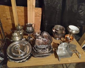 A bunch of silver platters and other silver items. Old time deli slicer 