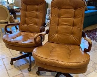 PAIR OF FRENCH STYLE, BUFF COLOR LEATHER SWIVEL CHAIRS ON CASTORS WITH CURVED WOOD ARMS AND NAILHEAD TRIM