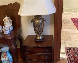 ANTIQUE BRASS LAMP WITH GARGOYLE DESIGN HANDLES ON CHINOISERIE STYLE WOOD BASE WITH SILK SHADE, ALSO SHOWING ANTIQUE PETITE CHEST