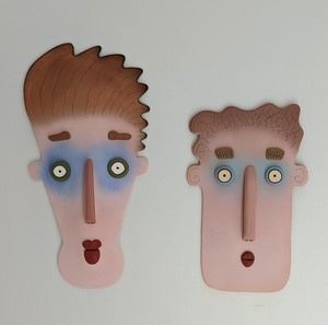 Pair of Unique Artist Designed Contemporary Face Sculptures. Fun wall hangings are signed by the artist, but difficult to read the signature. The largest measures 12” x 23”.