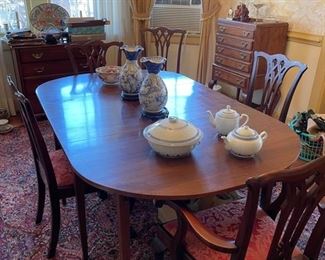 Henkel Harris dining room table.  Includes six chairs, one with restoration.  Also pictured in the background is a Kindel server and a mahogany silver flatware chest.