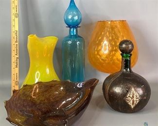 Decorative Houseware
One large Yellow glass pitcher, 11"Hx10"Wx7"D One Italian green glass decanter with leather like wrap with lid. 11"Hx6.6"W, shows some wear on the wrap and stopper. One large, tall blue bubble design glass covered jar, 18"Hx4"W. One brown glass contemporary designed centerpiece.4"Hx16"Wx10"D. One large orange pineapple themed glass wine goblet.23"Hx8.5"W.