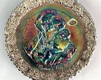 Fenton Mother's Day Plate
Iridescent plate with mother and baby surrounded by floral edging. Also has inscription on back commemorating Mother's Day. Front inscription stated Mother's Day 1972. 7.75" plate with minor wear on the bottom rim of the iridescence, otherwise no visible cracks or chips.