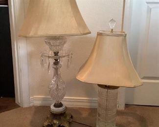 Crystal Styled Table Lamps
One lamp is clear cut glass cylinder shape with brass colored trim and base (base has some discoloration). Beige shade, 28"Hx6"W and turns on. The other lamp clear cut curved glass with brass and marble colored trim. It has chandelier style glass hanging decorative pieces. 30"Hx7"W. The beige shade has some areas where paint has dripped on it. It power on.