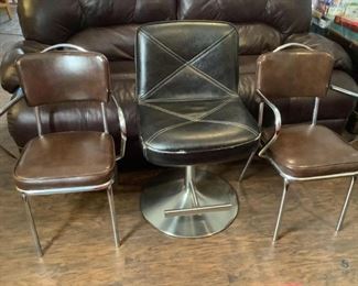 Metal Framed Side Chairs
Three (3) Chairs. Two (2) metal frame w/brown vinyl side chairs. H32" x W20" x D19". One (1) chairs has scuffs on back rest (see pictures). One (1) metal frame (base 20" round) black vinyl. H32" (extends to H43") x W20" x D20". Worn material on edges of chair (see photos).