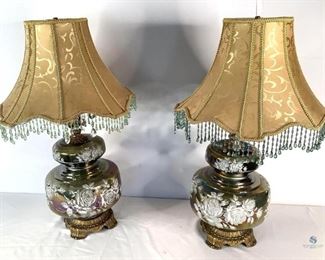 Vintage E. K. Carnival Glass Lamps
Pair of vintage 1972 E.K. amber carnival glass with painted white rose design. One lamp has turquoise beaded fringe on a gold fabric and brocade trim shade. The lamp works, however the nightlight part did not. Some beading is loose or missing. The other lampshade fringe is lime green and black. Lamp and nightlight work. Glass does not show any visible cracks or chips.