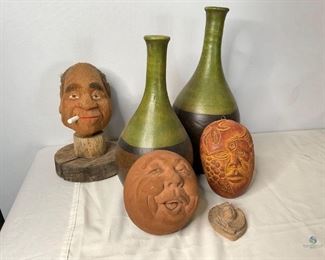 Interesting Home Decor
One sculpture of man smoking made from coconut on a wood base, 10"H. One clay jovial face, 5"H. One ceramic face with fish and berries, 6"H. One mini ceramic angel face, 3.5"H. Two matching green and brown ceramic vases made in Mexico, 15"H and 12"H. No visible damage.