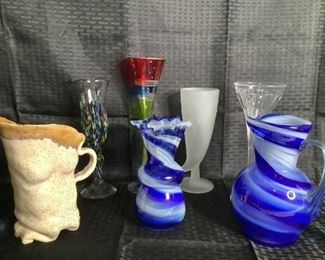 Colorful Glassware
One blue and white swirl pitcher with matching ruffle edge vase. One frosted white pilsner glass. One Multi-colored champagne flute. One cut glass champagne flute. One clear and multi-colored speckled design curved mimosa glass. One tan and brown pottery pitcher. 