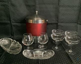 Ice Bucket and Delicate Drink Ware
One red and silver tone ice bucket with lid. Two cut glass snack trays. Two small clear glass brandy sniffers. Four (4) small champagne glasses.