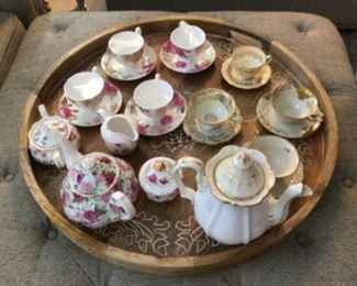 Pretty cups, saucers, teapots on large wood tray