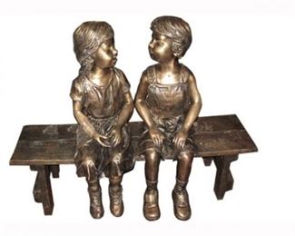 Bronze statue of boy and girl on bench. 